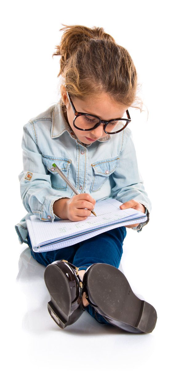 Young girl in glasses sitting on the floor writing in a notebook