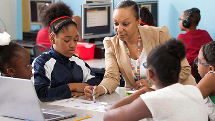 A teacher working with a small group of students at a table